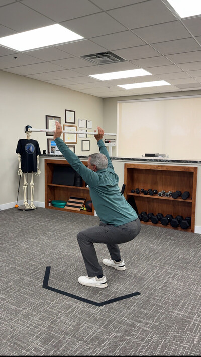 Dr. Carter performing a golf performance screen on a patient at inmotion chiropractic