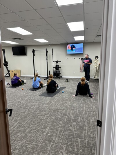Dr. Carter instructing high school athletes on their mobility and movement screen at InMotion Chiropractic